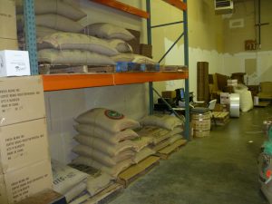 Warehouse with large burlap sacks of coffee beans on shelves