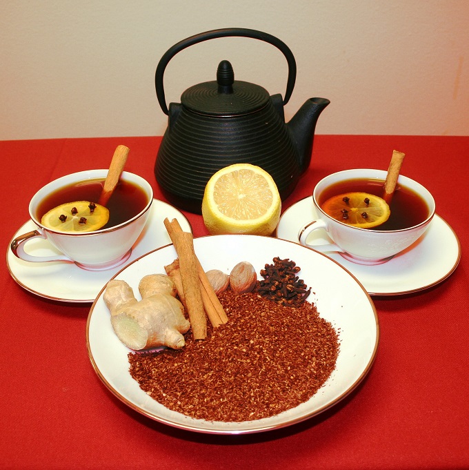 Loose leaf tea and warm Rooibos Cocktail ingredients in a bowl next to teacups and a teapot