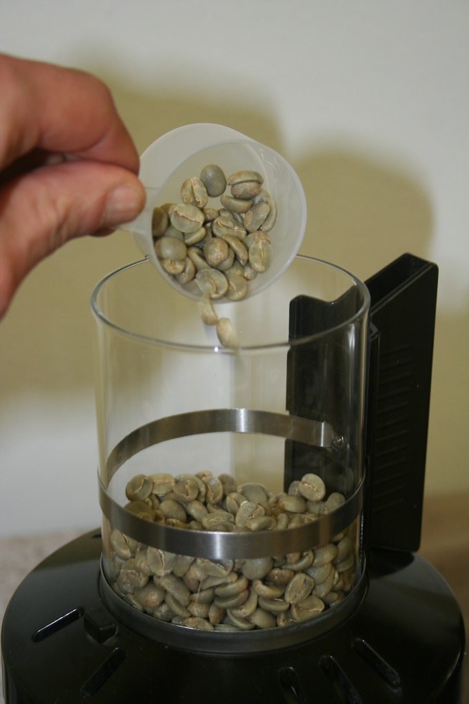 pouring green coffee beans into roaster