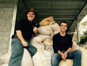 David and Keith Pech sitting on a pile of large sacks of coffee