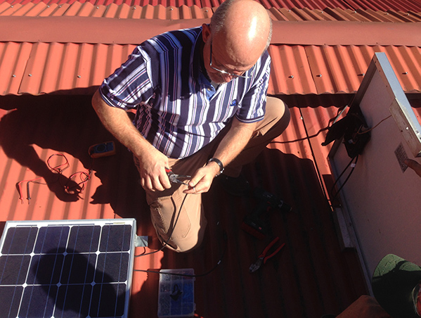 Damarli installing solar panels on roof in Panama