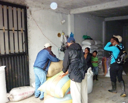 Workers moving large sacks of coffee beans in Bilbao warehouse, Colombia