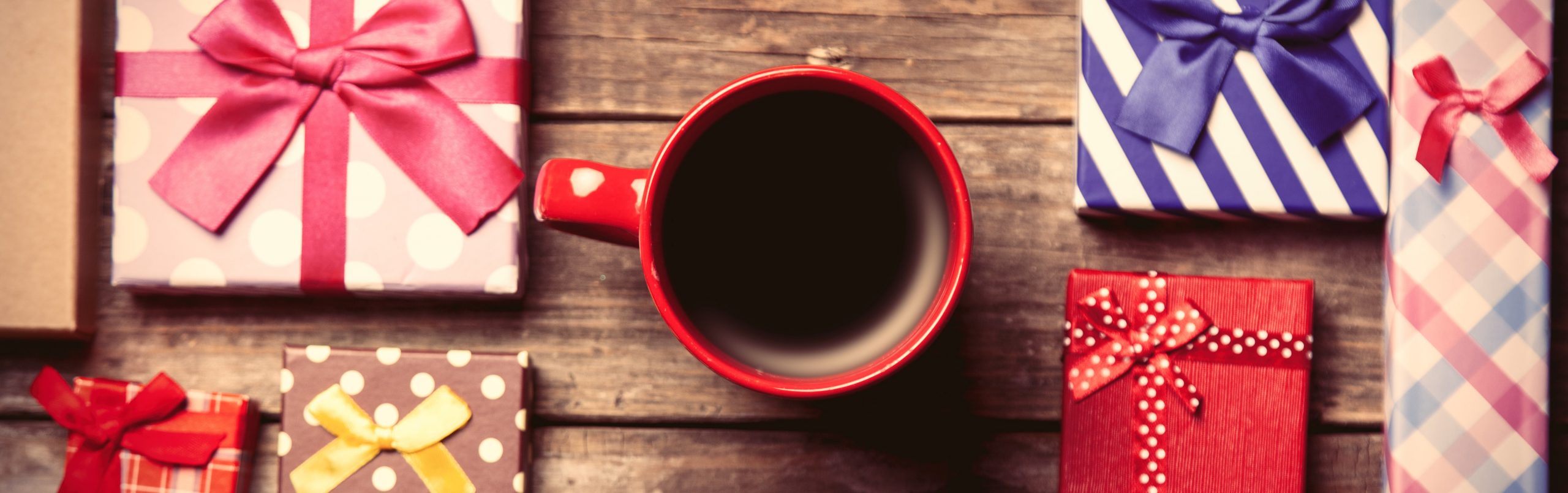 Gifts and cup of coffee on a table