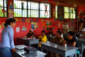 Teacher and students in a classroom at Finca Tasta, Peru