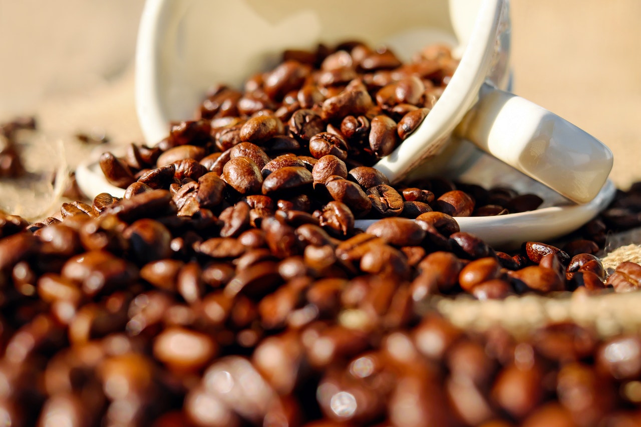 Coffee beans spilling out of cup