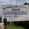 Man standing in front of sign for sign for Tekangu Karagoto in Kenya Nyeri
