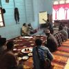People sitting on a rug eating during Indonesian coffee worker training