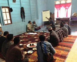 People sitting on a rug eating during Indonesian coffee worker training