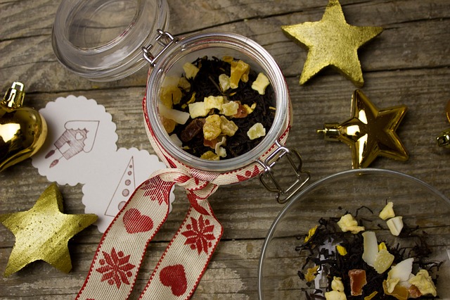 Looseleaf tea in a jar wrapped in holiday ribbon with ornaments around it