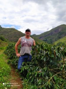 Ederval Sartori standing with coffee plants in Brazil