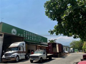 Trucks loaded with bags of coffee beans outside Cooperativa Cuzcachapa de Ri